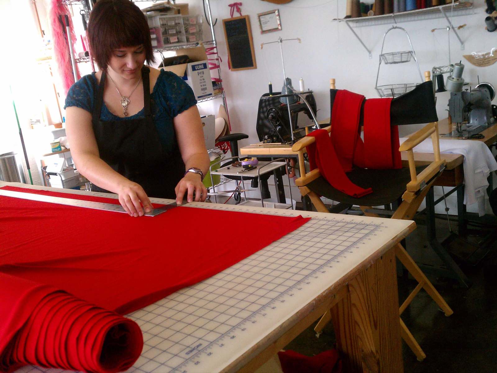 a woman cutting fabric on a table