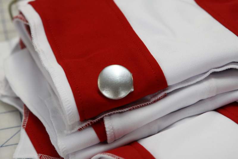 a close up of a button on a red and white shirt