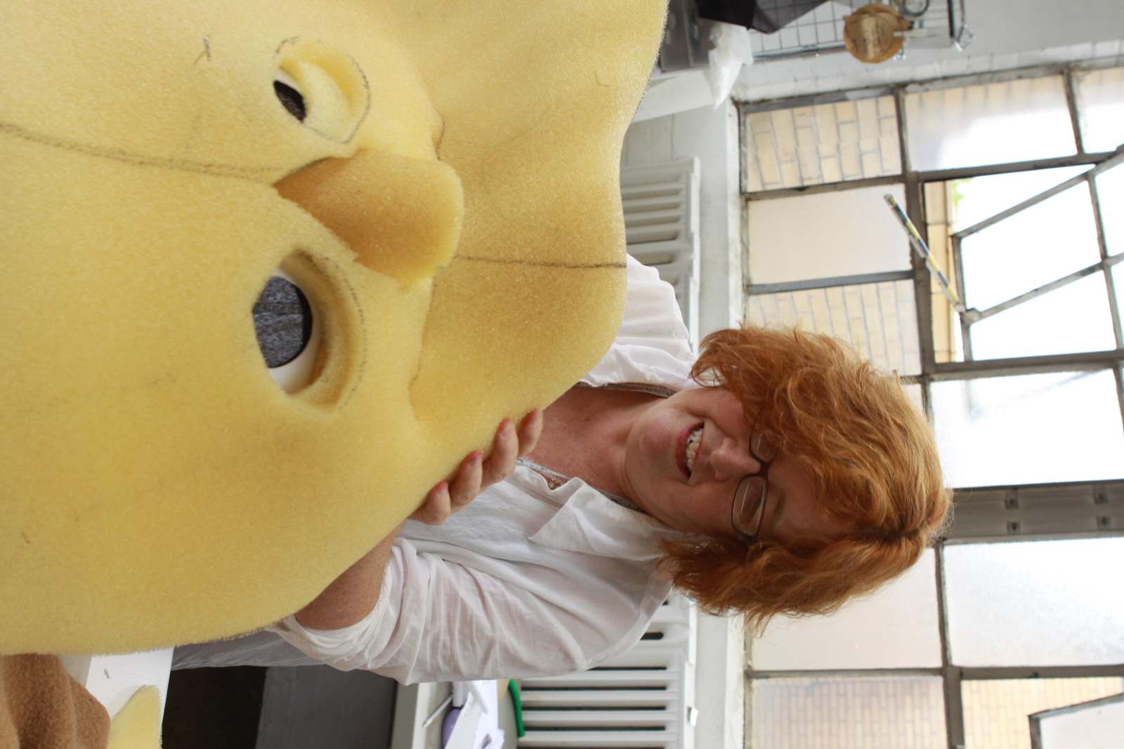 a woman holding a yellow stuffed animal