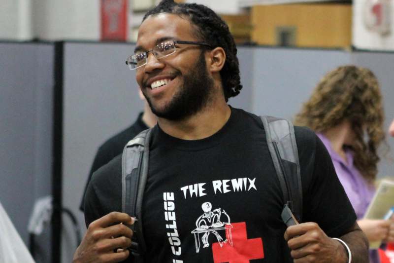 a man smiling with a backpack