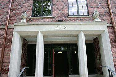 a building with columns and owls on the front