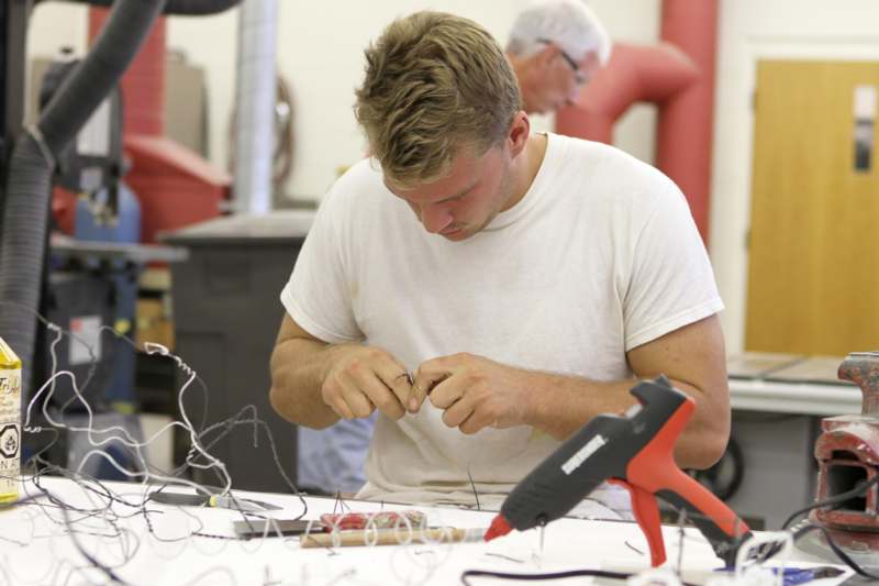 a man working on a piece of wire