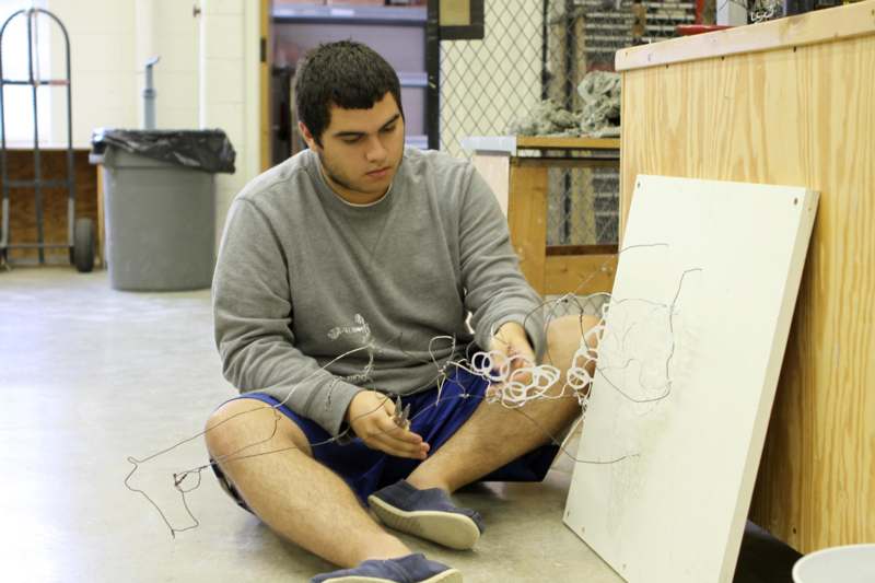 a man sitting on the floor holding wires