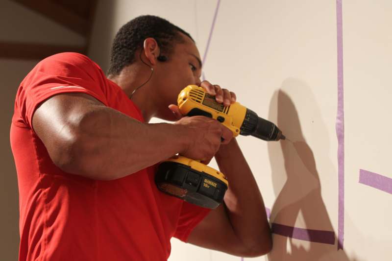 a man using a drill to drill a wall