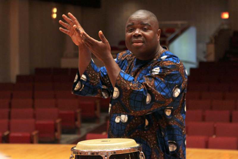 a man in a blue shirt playing a drum