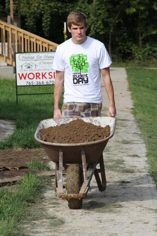 a man pushing a wheelbarrow with dirt