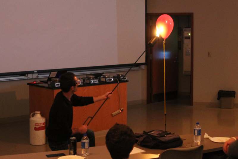 a man holding a balloon with a stick