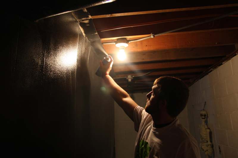 a man spraying a wall with a light bulb