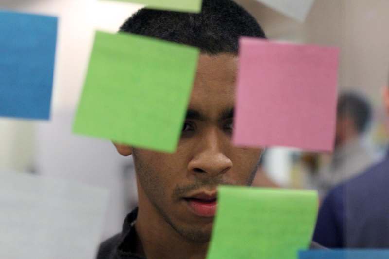 a man looking through a window with many post-it notes