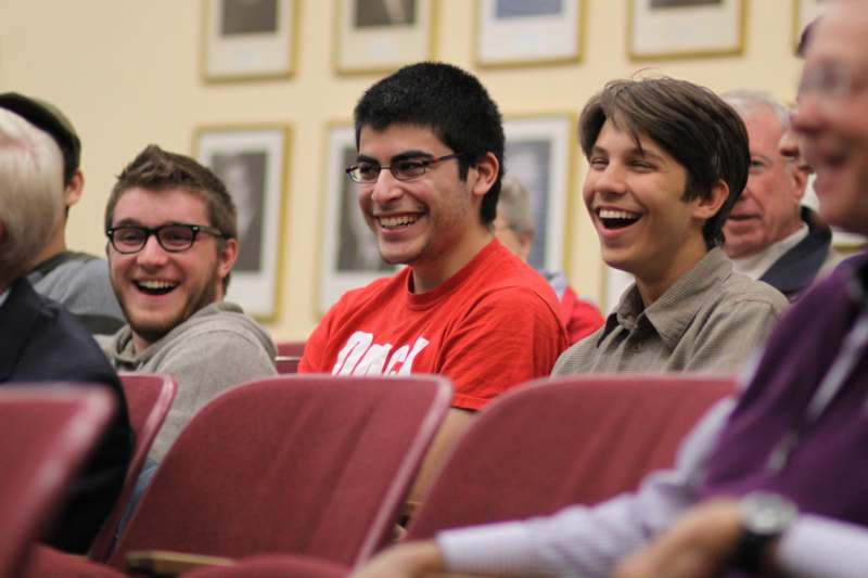 a group of people laughing in a lecture hall