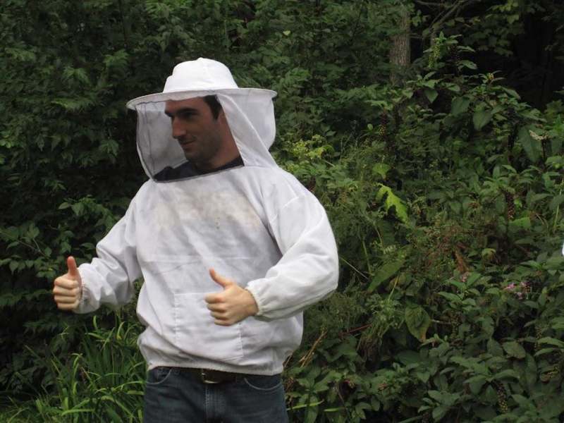 a man wearing a beehive and holding his thumbs up