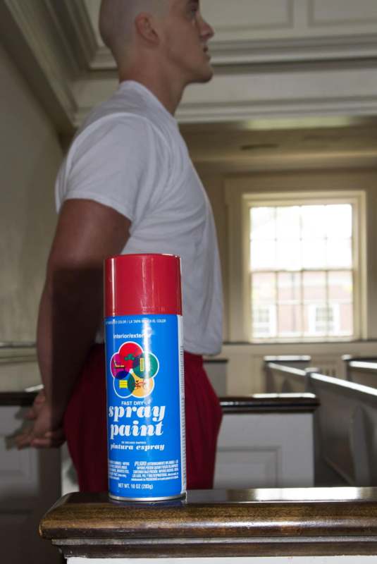 a man standing in a room with a spray can
