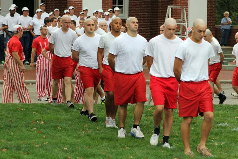 a group of men in red shorts and white shirts walking on grass