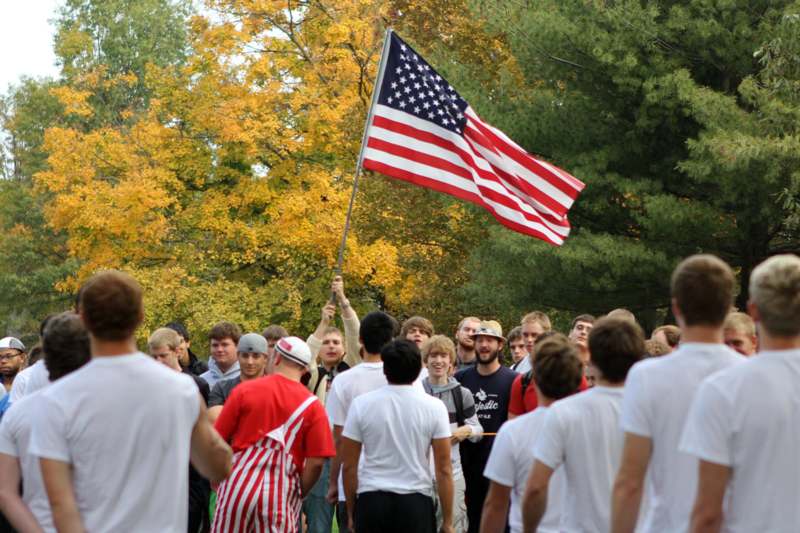 a group of people standing in a line with a flag
