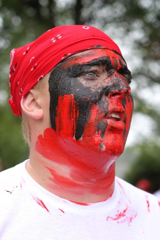 a man with black and red paint on his face