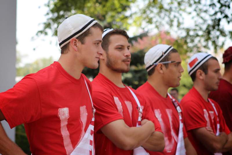 a group of men wearing red shirts and white hats