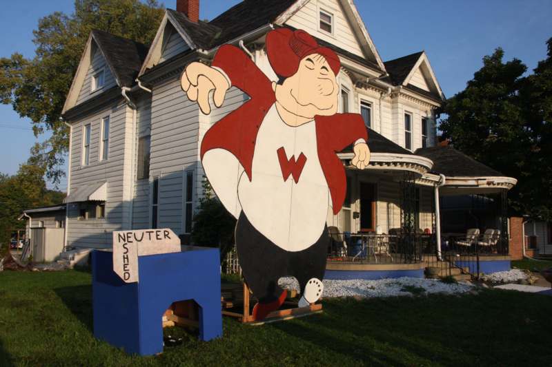 a large wooden cutout of a cartoon character in front of a house