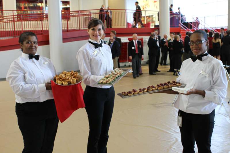 a group of people holding trays of food