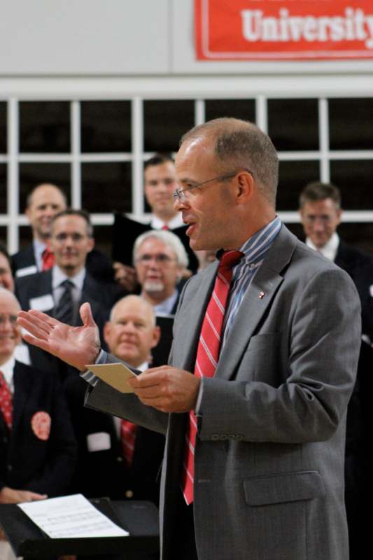 a man in a suit speaking to a group of people