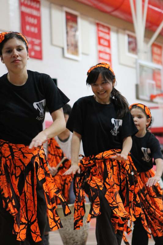 a group of girls in orange and black skirts