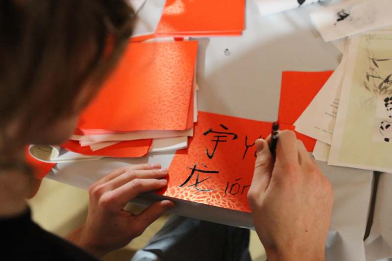 a person writing on a red paper