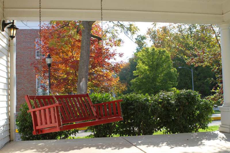 a red swing from a porch