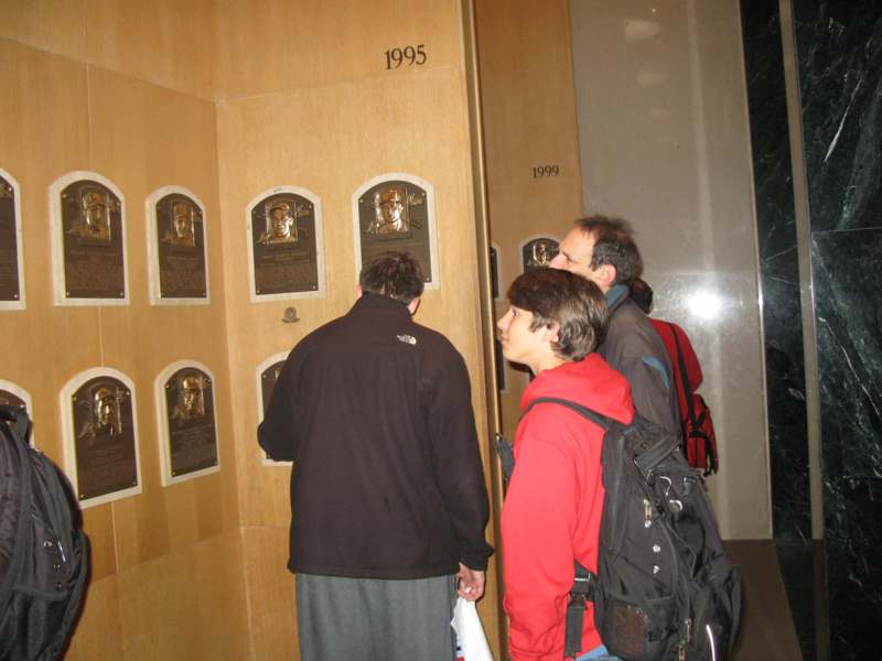 a group of people looking at plaque on a wall