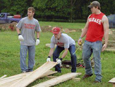 a group of men working on a wood plank
