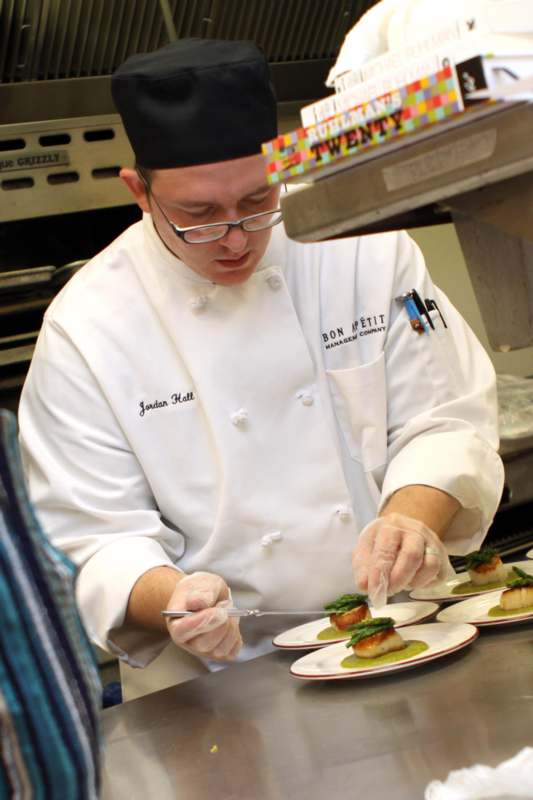 a chef preparing food on plates