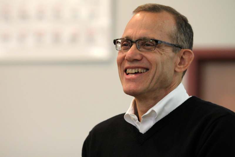 a man wearing glasses and a black sweater
