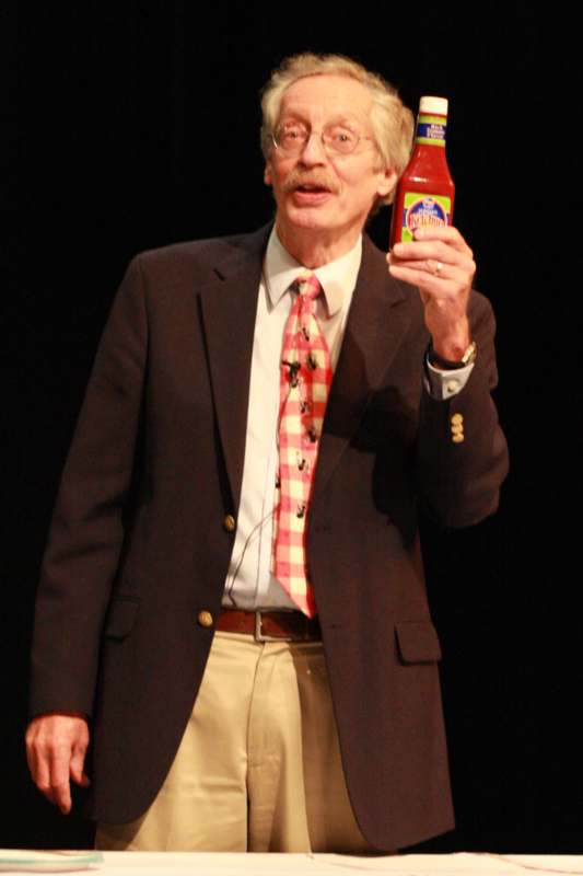 a man holding a bottle of hot sauce