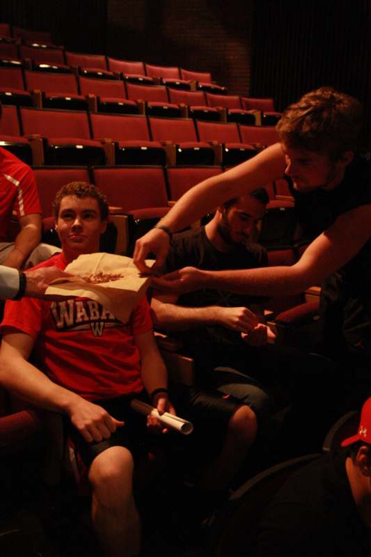 a man giving food to a man in a movie theater