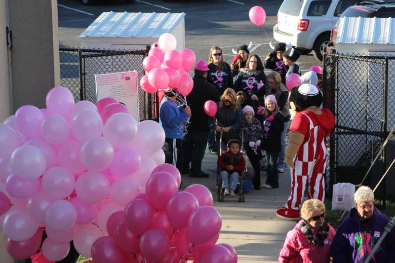 a group of people with pink balloons