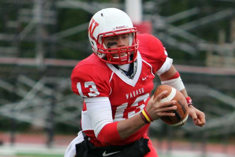 a football player in a red uniform holding a football