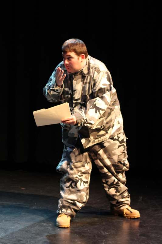 a man in camouflage clothes holding a piece of paper
