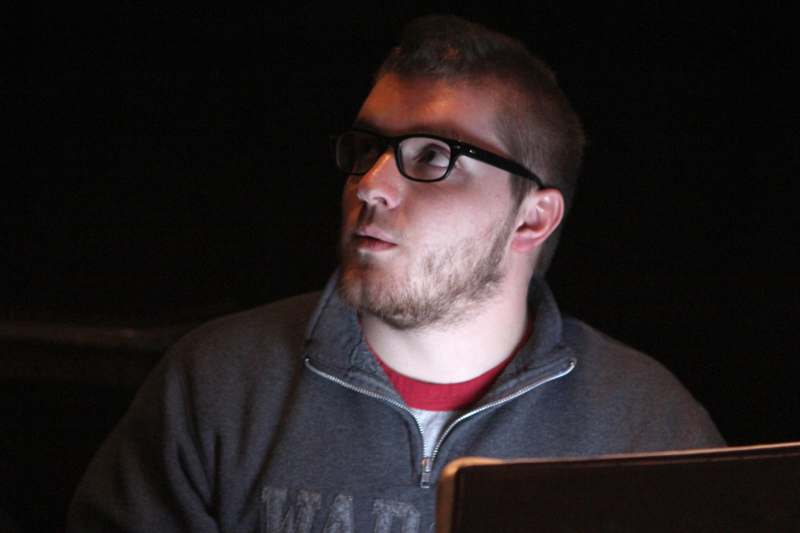 a man wearing glasses and a grey sweatshirt