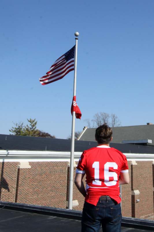 a man standing in front of a flag pole
