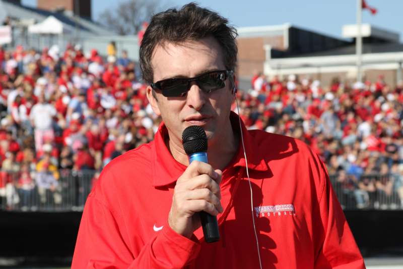 a man wearing sunglasses and holding a microphone