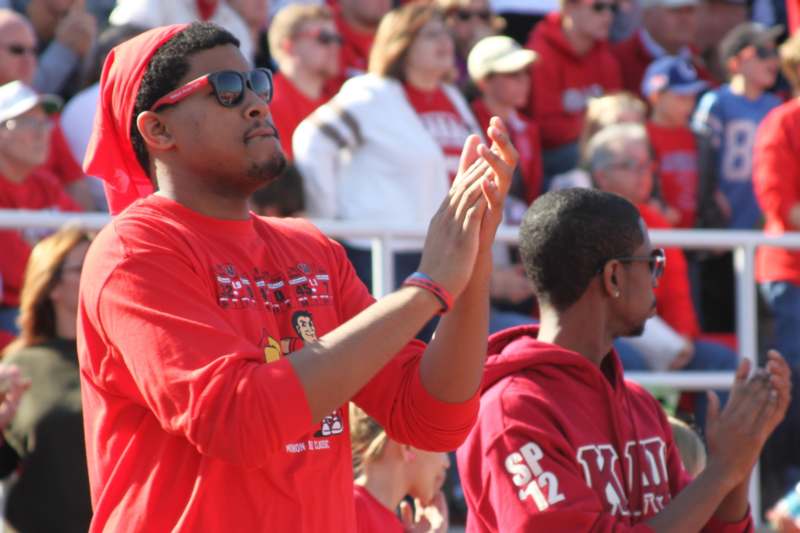a man in red shirt and sunglasses clapping