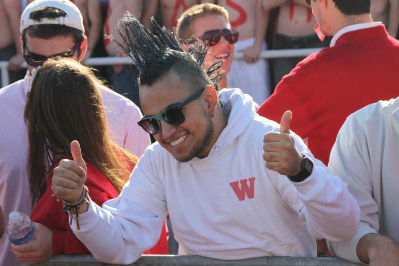 a man with mohawk hair and sunglasses giving thumbs up