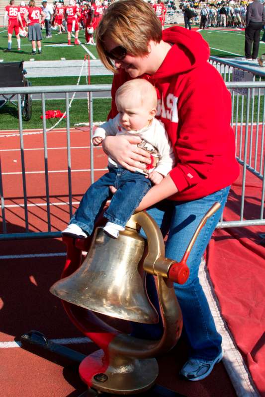 a woman holding a baby on a bell