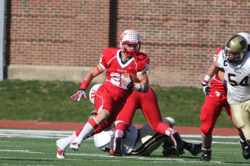 a football player in red uniform running with the ball
