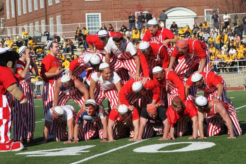 a group of people in red and white striped uniforms on a football field