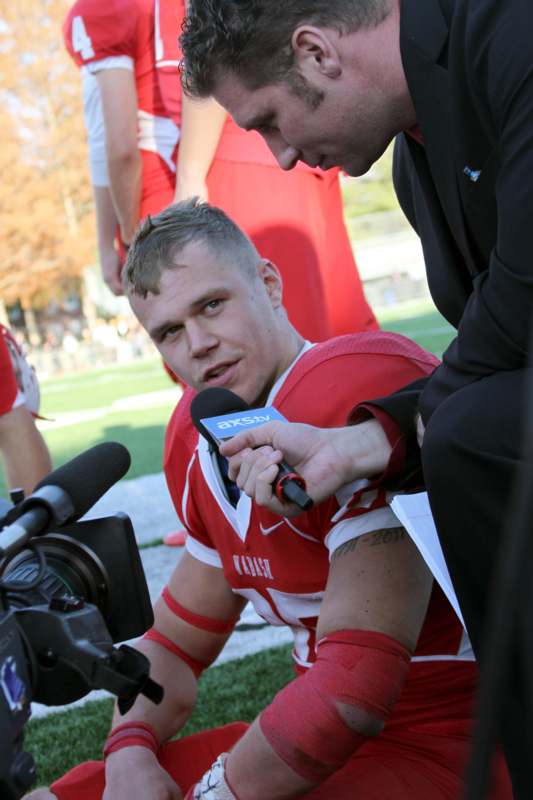 a man in a red jersey holding a microphone