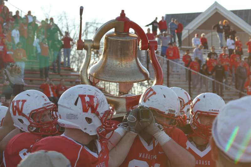 a group of football players holding a bell