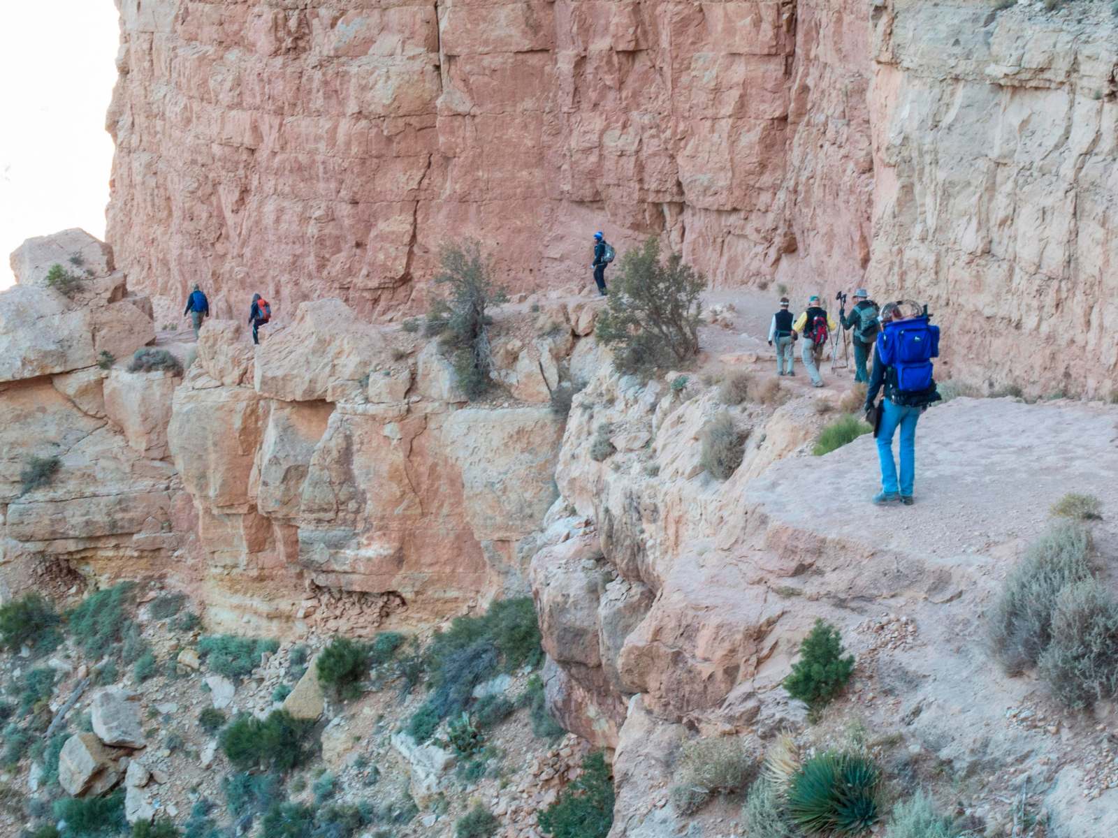 a group of people walking on a rocky cliff