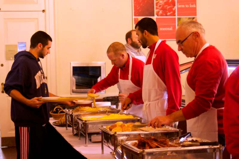 a group of men in aprons serving food