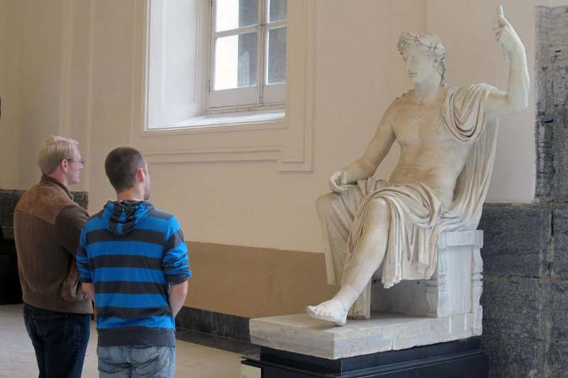 a man looking at a statue