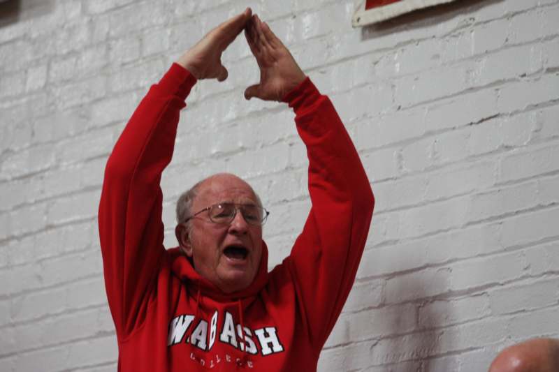 a man in a red sweatshirt with his hands up over his head