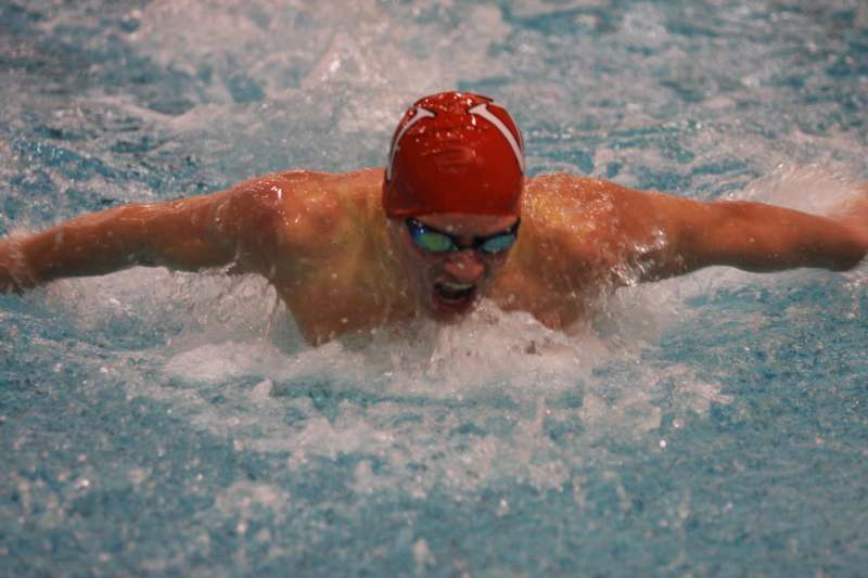 a man in a swimming cap and goggles swimming in a pool